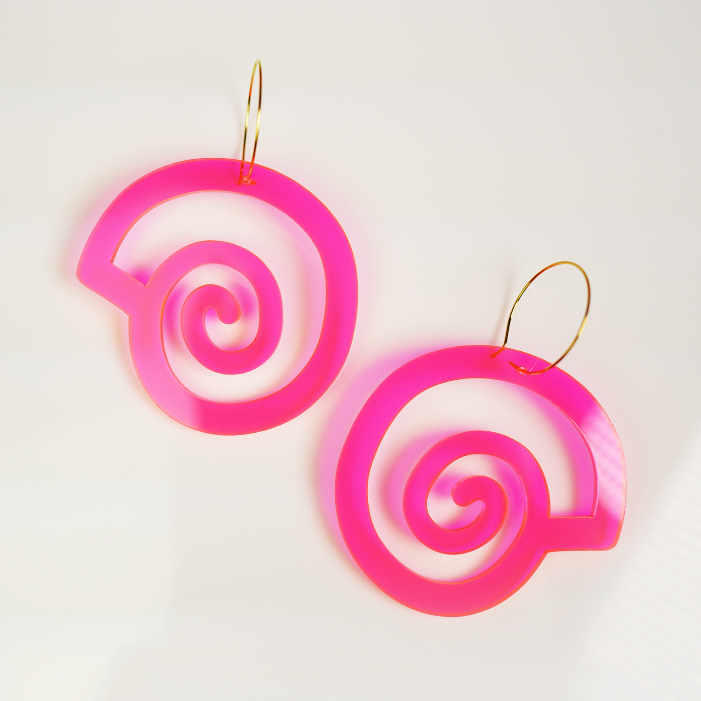 Scallop shell earrings made from laser-cut pink acrylic with stainless steel hoops, handmade in Melbourne