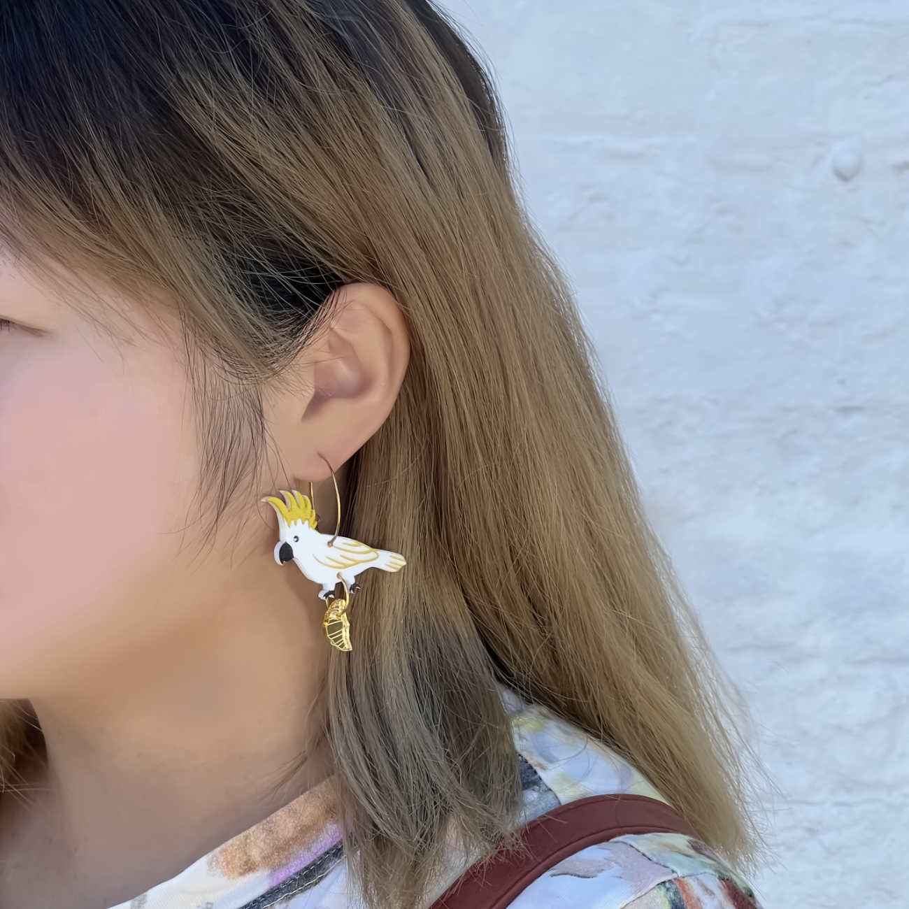 Sulphur crested cockatoo with croissant gold hoop earrings