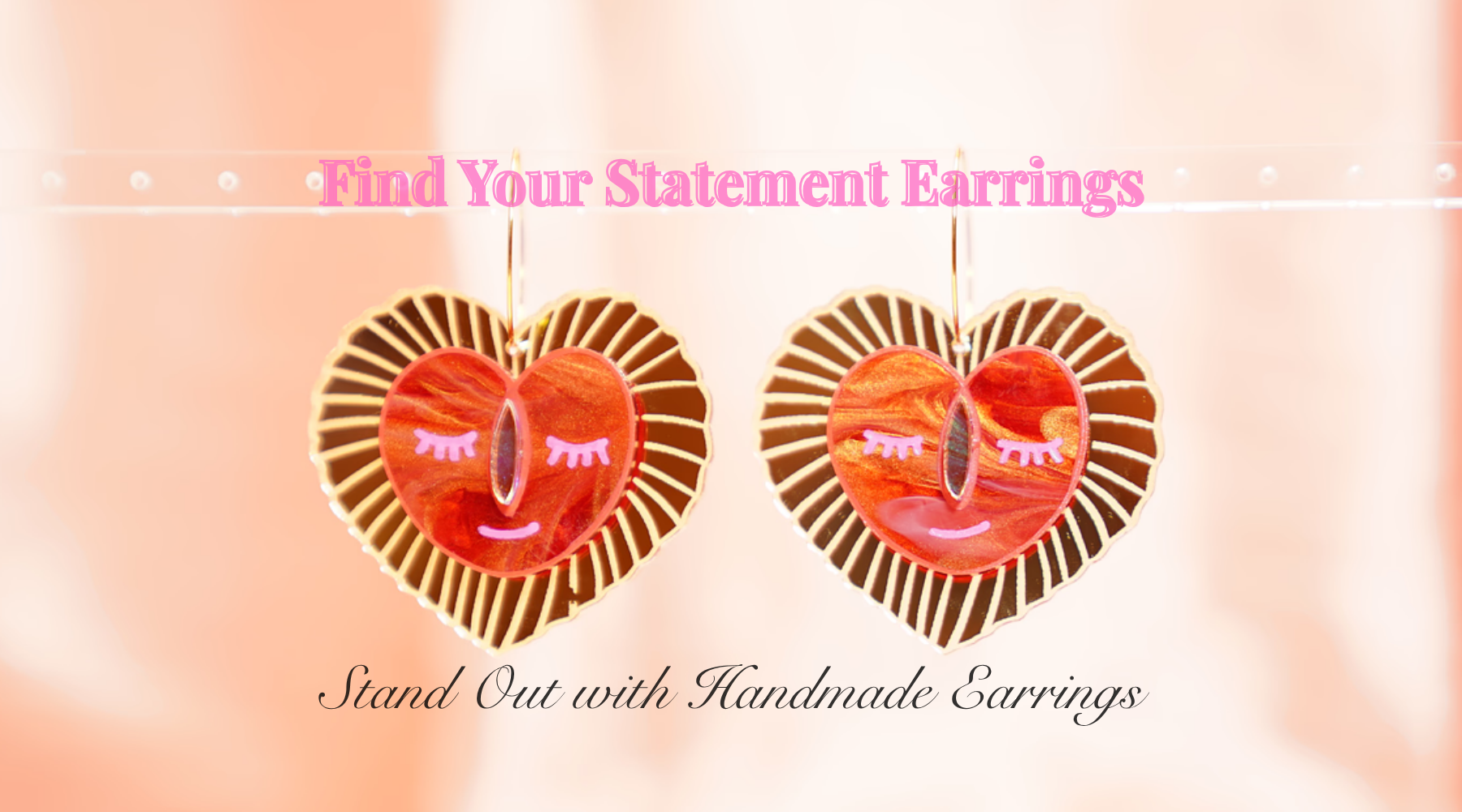 Heart-shaped earrings with a pink and orange design on a soft pink background.